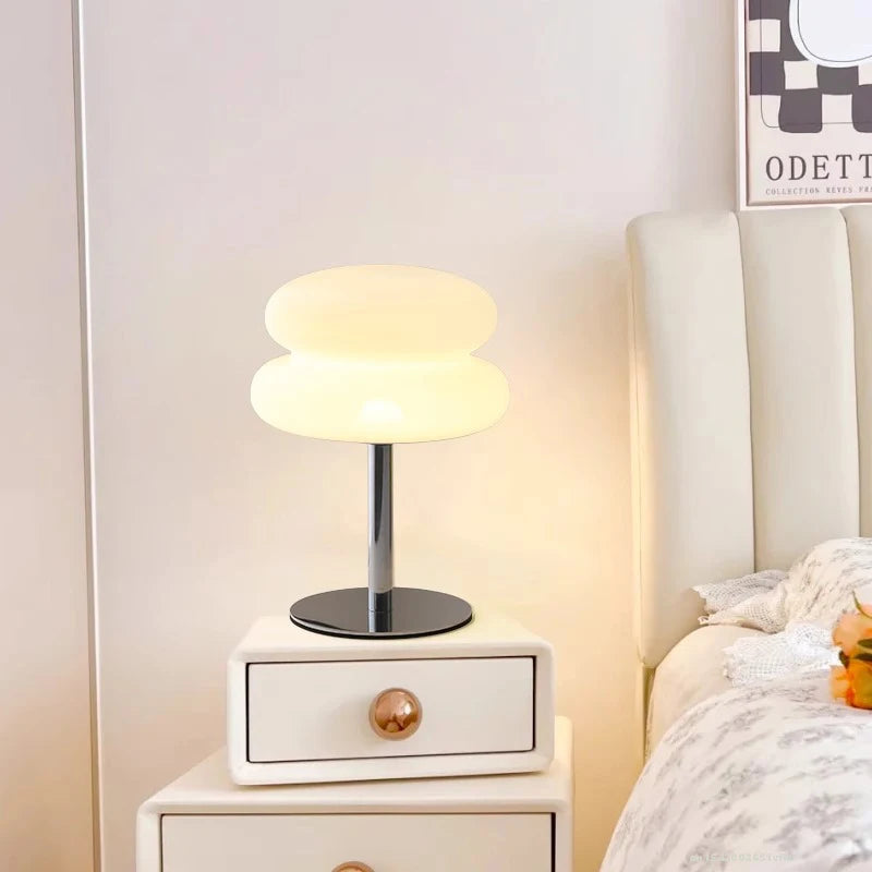 Mushroom-style LED lamp on a nightstand by a bed