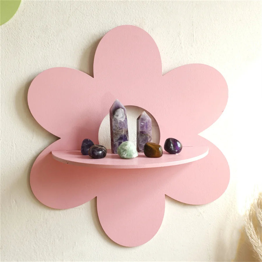 Pink flower-shaped floating wall shelf displaying crystals and stones