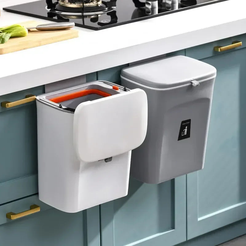Wall-mounted white and dark gray rectangular trash bins with lids on a kitchen cabinet