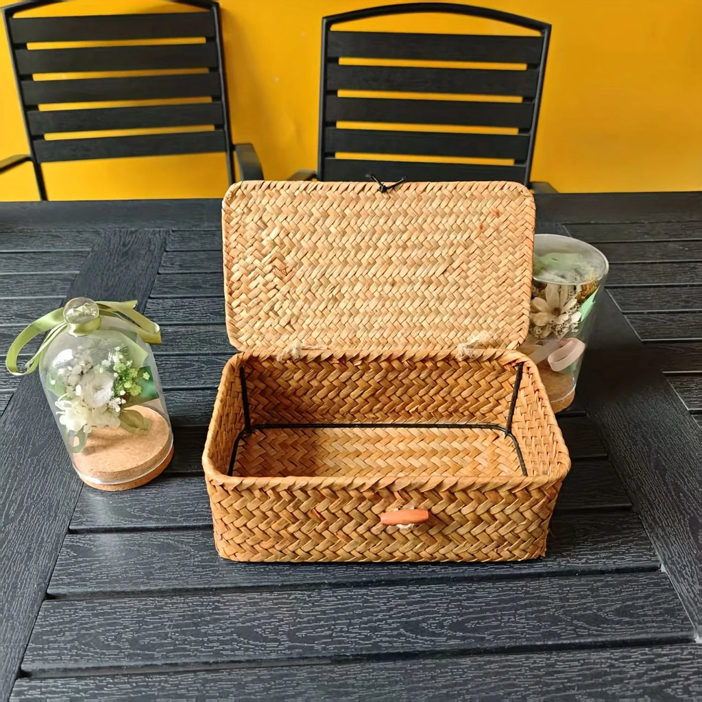 Open lidded woven bamboo storage basket on a table with decorative items