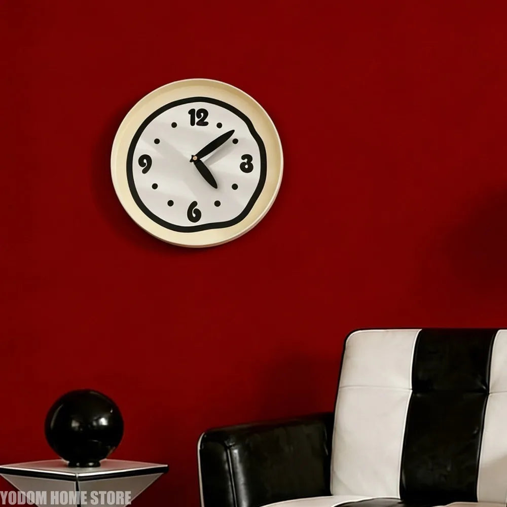 Cream round wall clock with black edge displayed on red accent wall in a modern living room