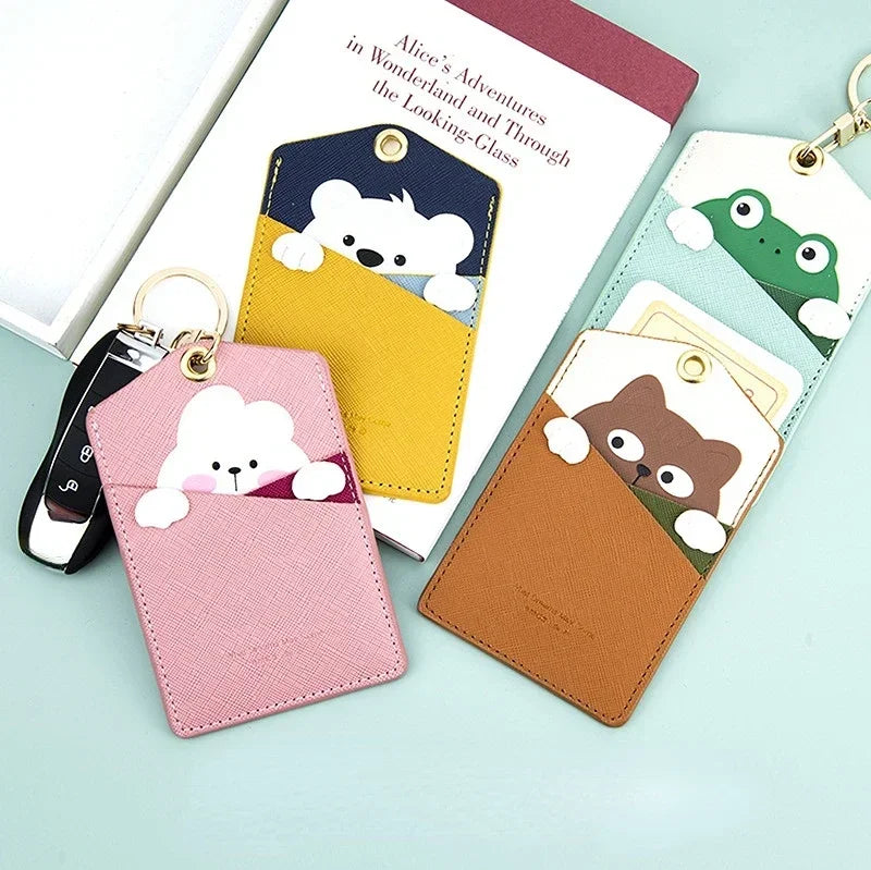 Assorted animal card holder keychains with bear, frog, and cat motifs shown on a table