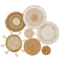 Seven handwoven rattan and wicker wall baskets, assorted natural patterns on a white background