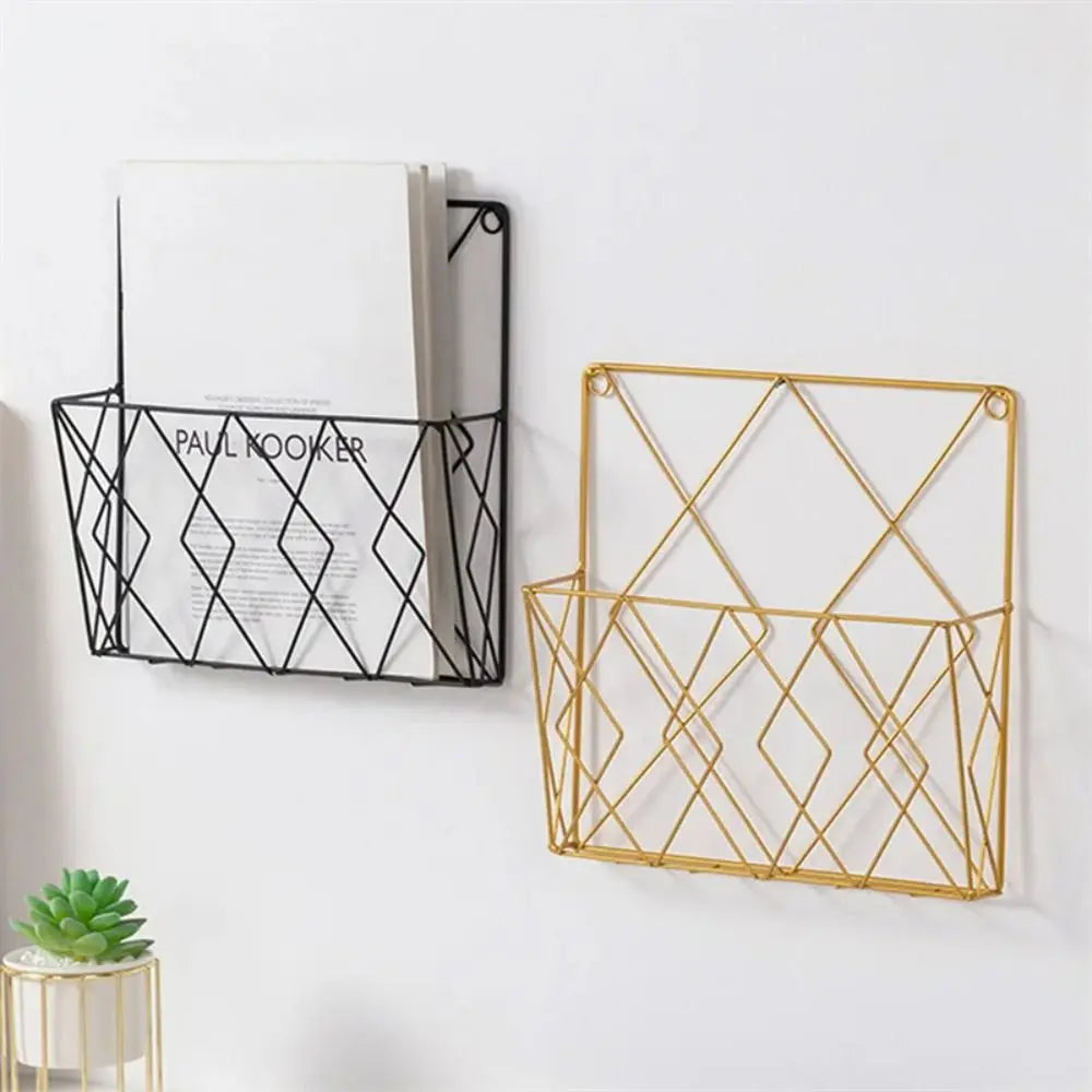 Black and gold geometric metal wall-mounted magazine racks shown side by side on a white wall, holding papers.