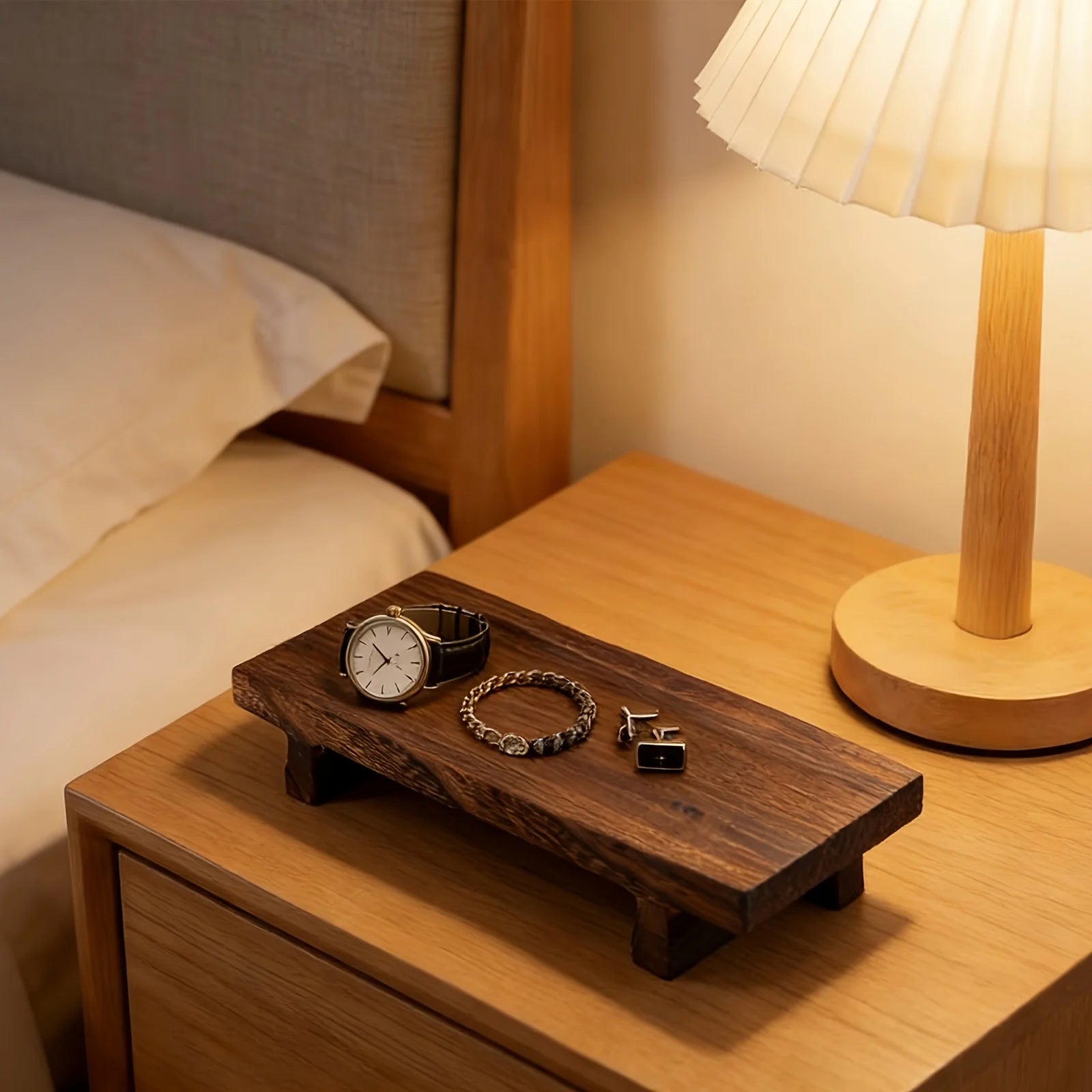 wooden tray on nightstand with watch, bracelet, and lamp
