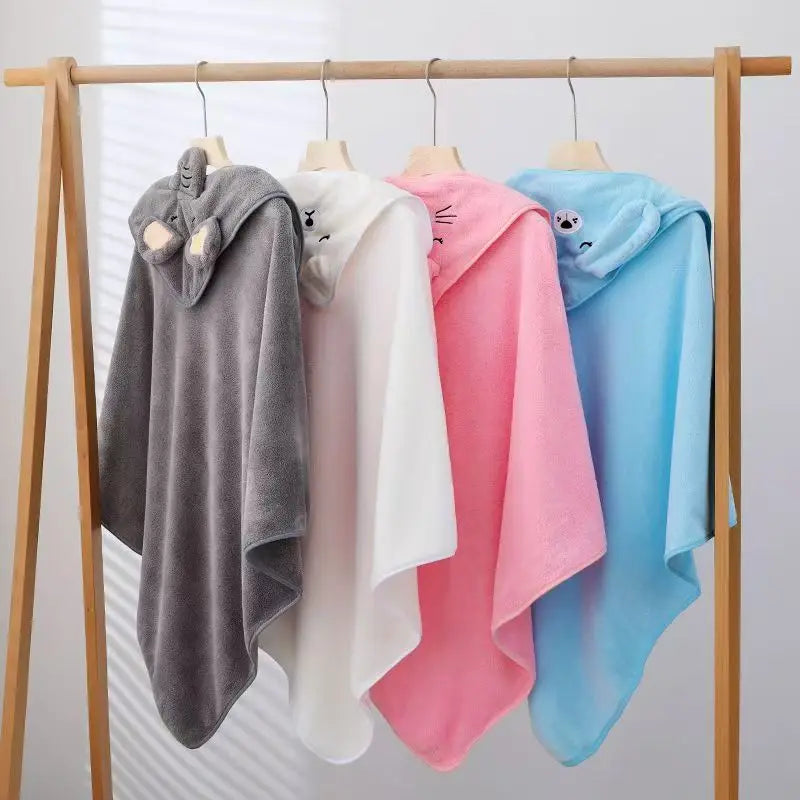 Four animal hooded towels in gray, white, pink, and blue hanging on wooden rack