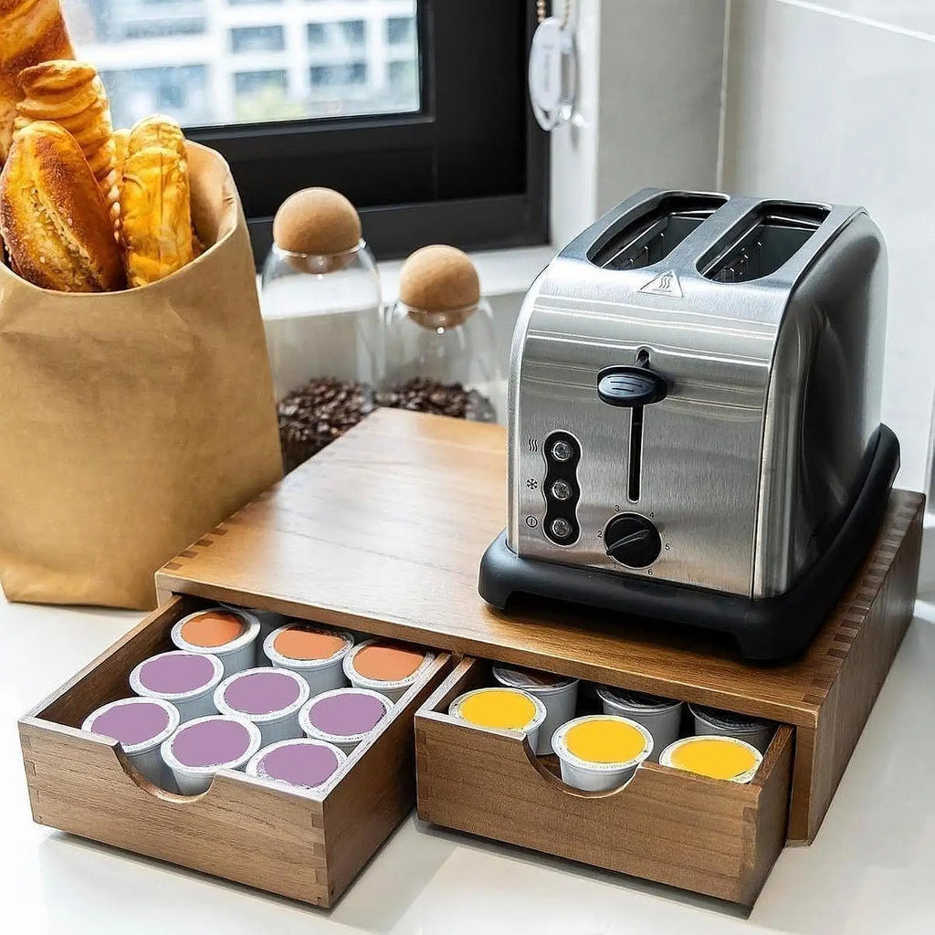 Wooden organizer under a toaster, drawers filled with coffee capsules, on kitchen counter