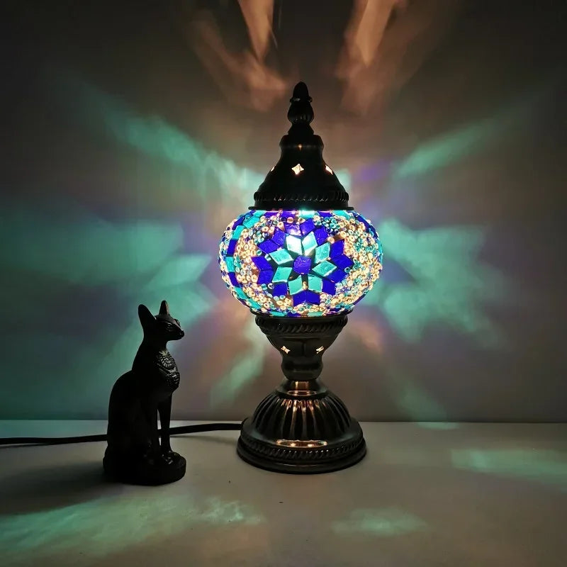 Stained glass mosaic table lamp with blue and turquoise pattern glowing on table