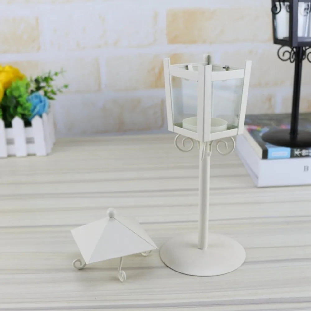 White lantern-style candle holder with removable top on table