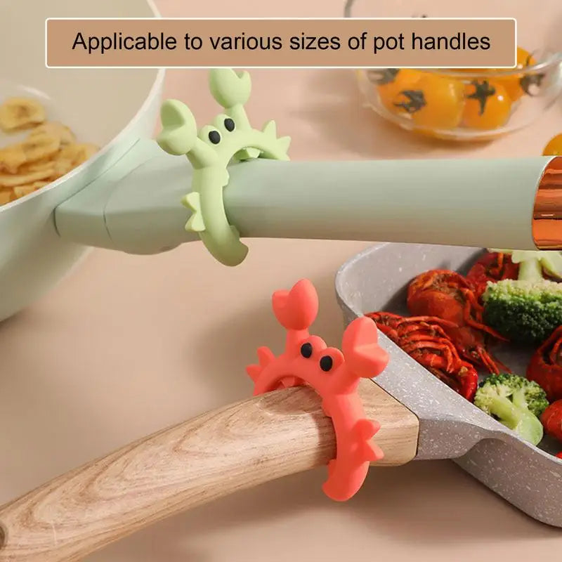 Red and light green crab-shaped silicone utensil rests attached to different sized pot handles near kitchen ingredients