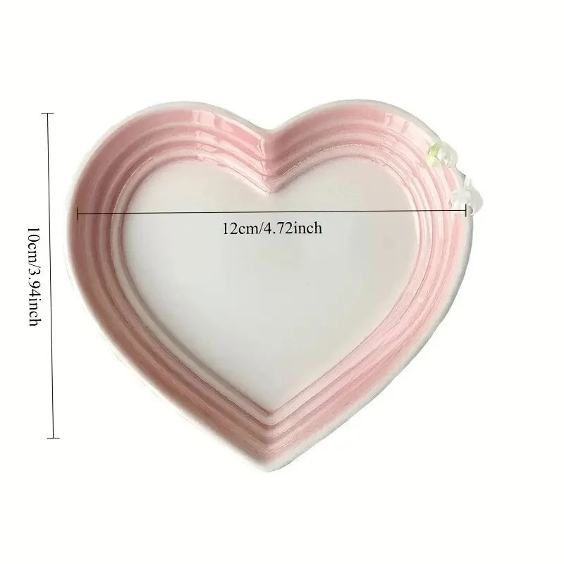 Heart-shaped ceramic plate in pink-white shown with 12cm width and 10cm height measurement