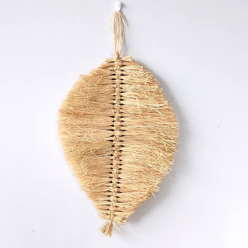 Close-up of handwoven leaf-shaped raffia wall hanging with hanging loop