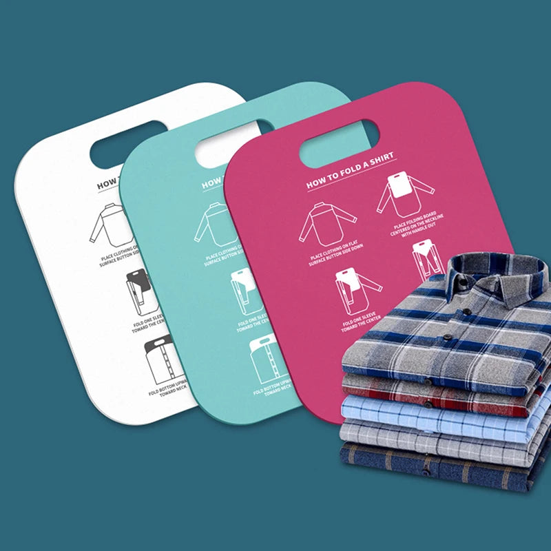 Three plastic clothes folding boards in white, mint green, and magenta, with a folded stack of shirts beside them