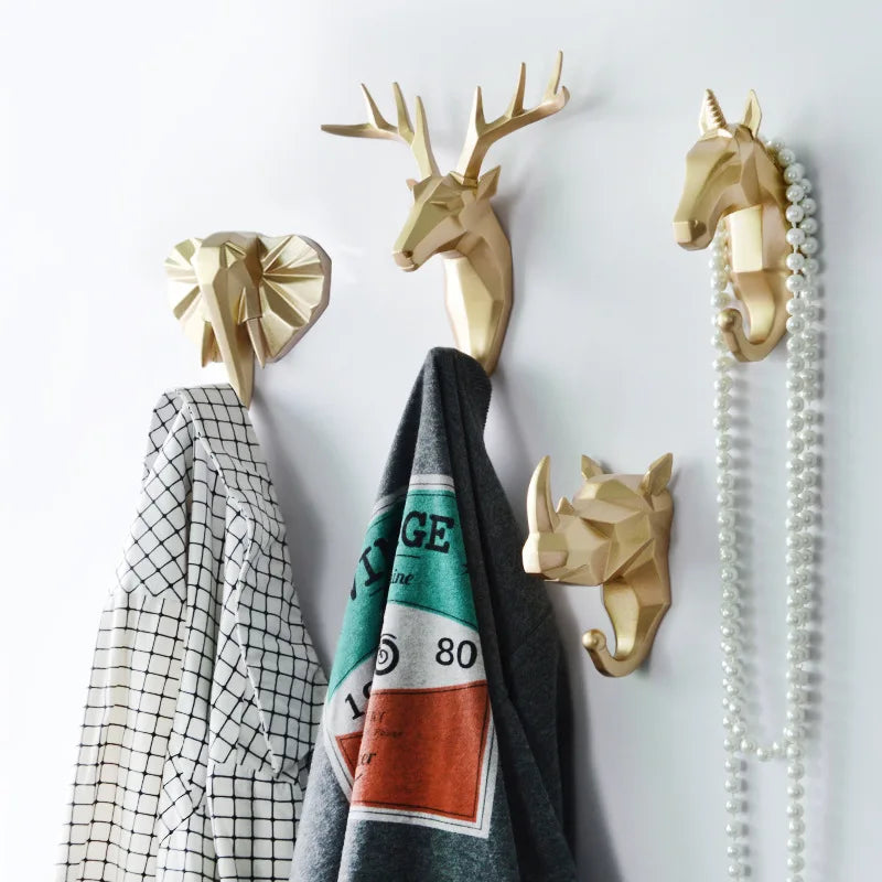 set of four animal head resin wall hooks with clothes and jewelry hanging in entryway