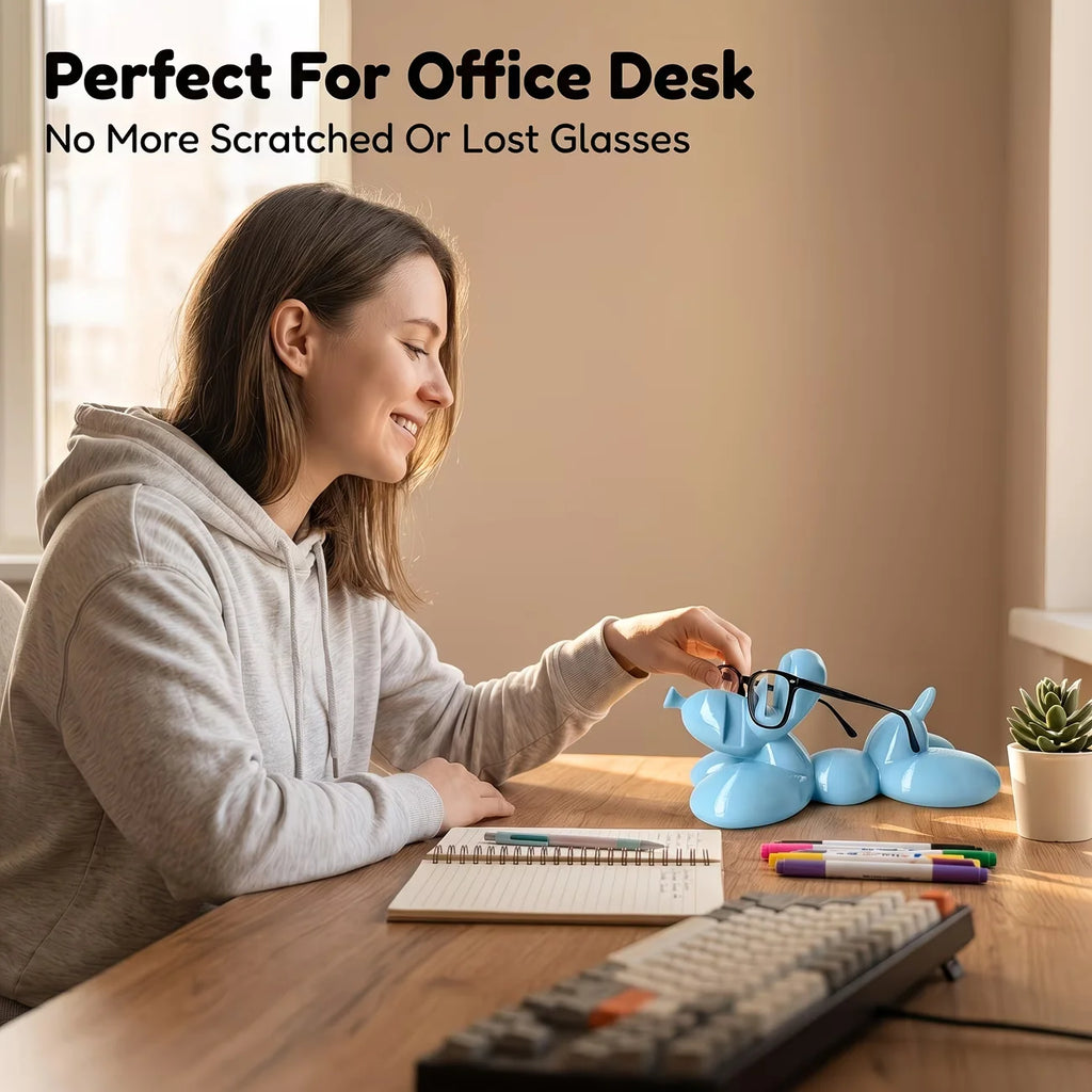 Blue balloon dog eyeglass holder on a desk with a woman placing her glasses on it
