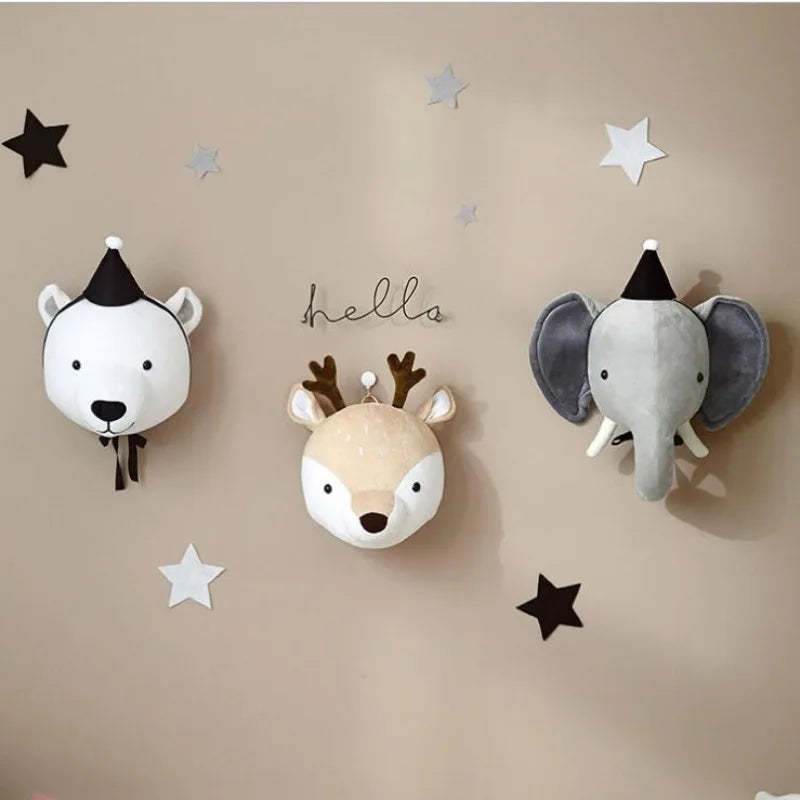 Three fabric animal face wall hangings (bear, deer, elephant) on a beige wall with star decals