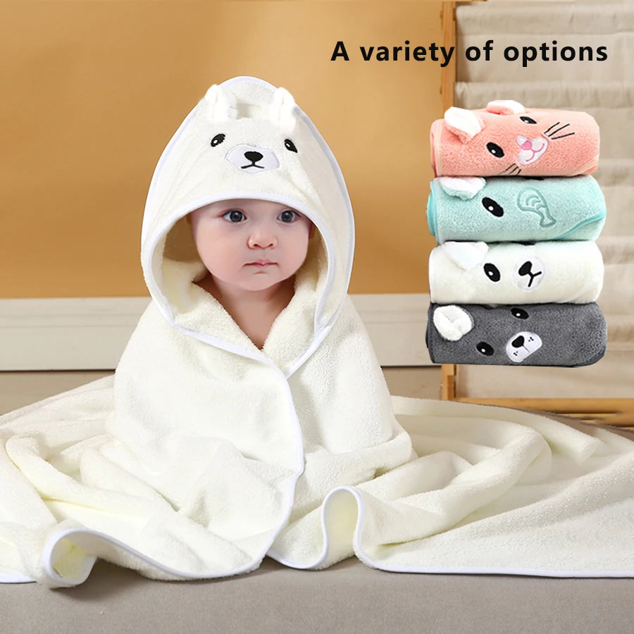 Baby wrapped in a white animal hooded cartoon towel with a stack of other folded animal hooded towels shown