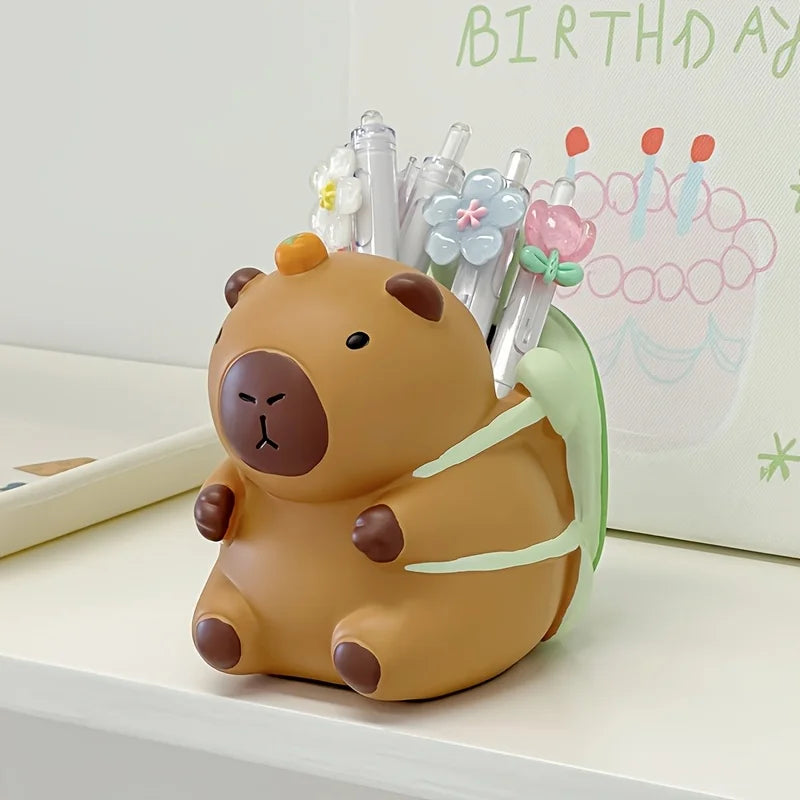 Capybara pen holder on a shelf with pens and a birthday card in the background