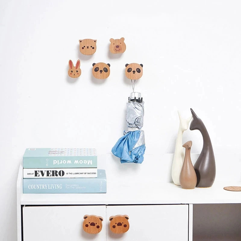 Animal wall hooks displayed above a console table with books and animal figurines.
