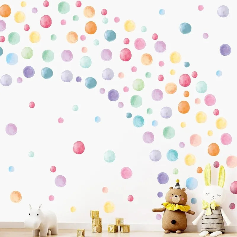 Pastel rainbow polka dot decals on a wall above plush toys and wooden blocks