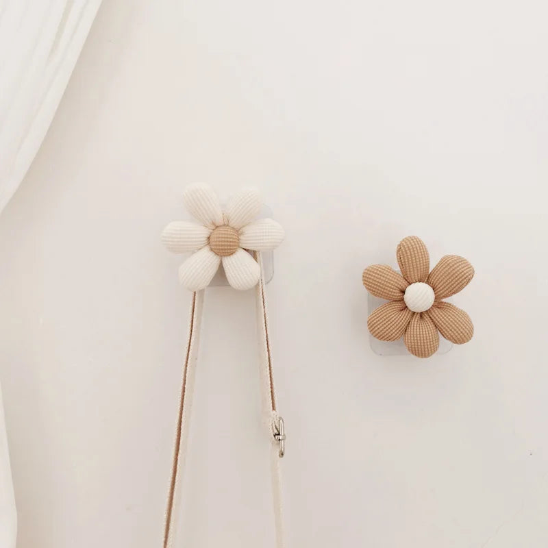 Set of decorative flower wall hooks in neutral tones on a wall, used as accessory hangers