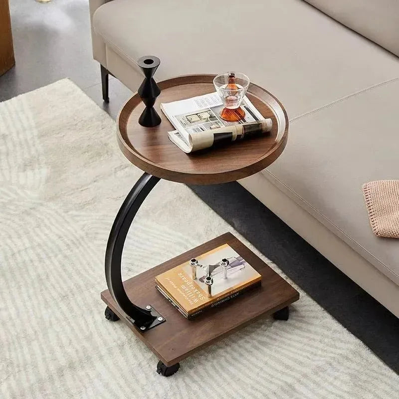 Round rolling side table with storage shelf next to sofa in living room