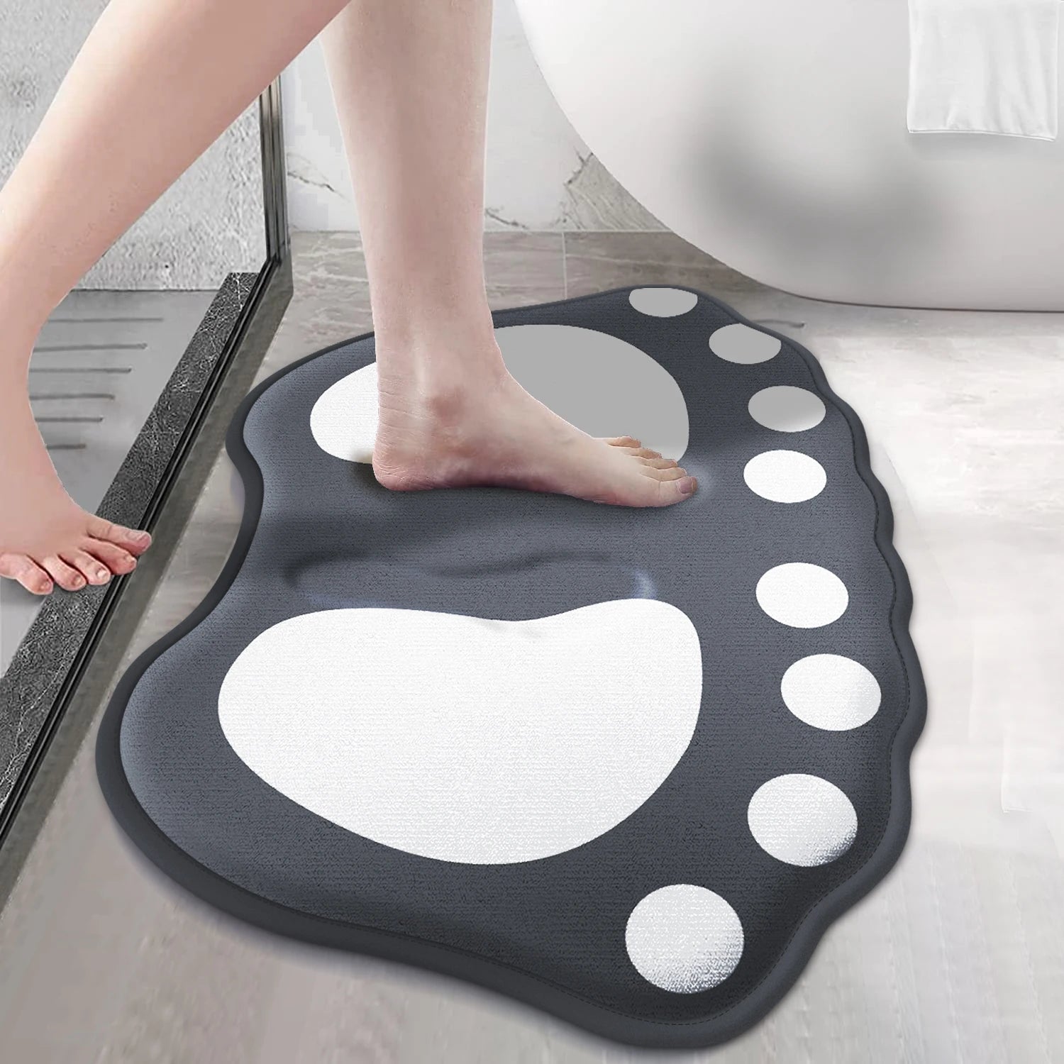 Person stepping onto grey claw pattern anti-slip bath mat beside shower