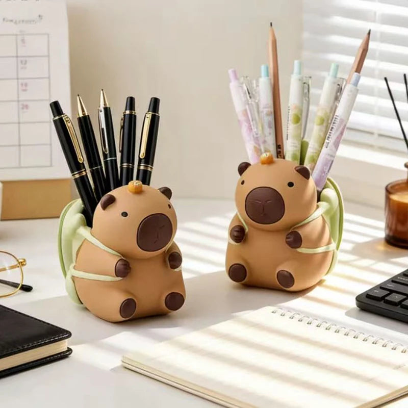 Two resin animal pen holders holding pens on a bright study desk