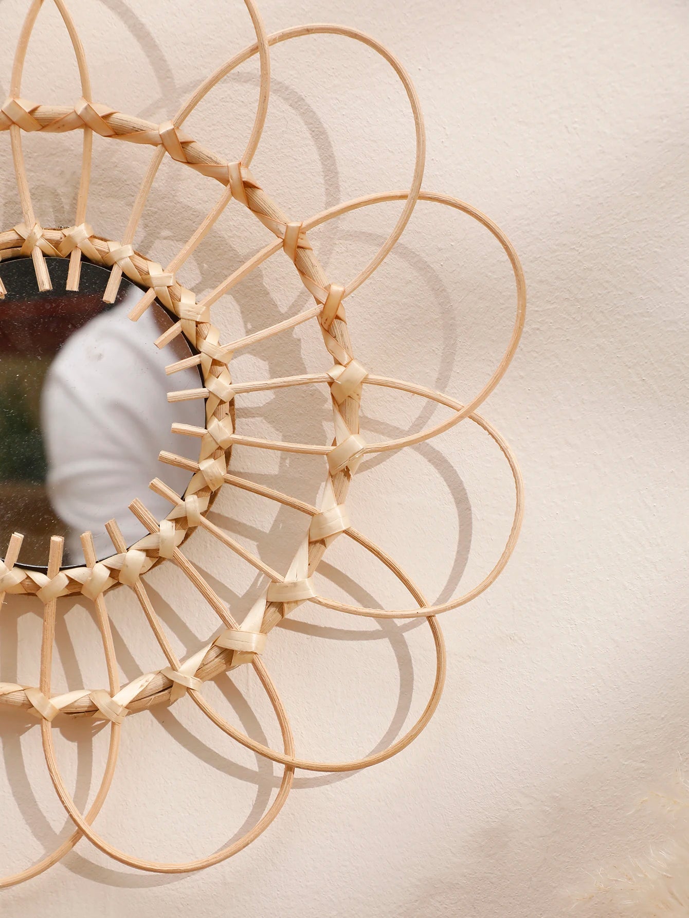 Detail of handwoven rattan frame and mirror edge in natural light