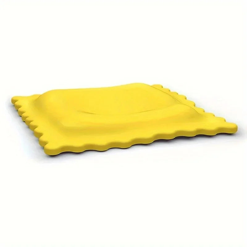 Cartoon biscuit-shaped yellow silicone spoon rest against a plain white background