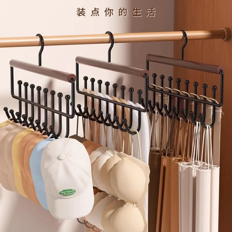 Three wooden organizer racks hanging on a closet rod, holding hats, caps, and accessories