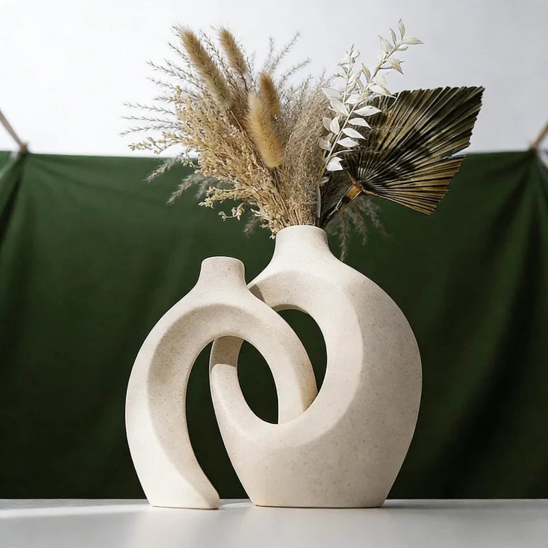 modern sculptural resin vase in white with dried botanical arrangement on table