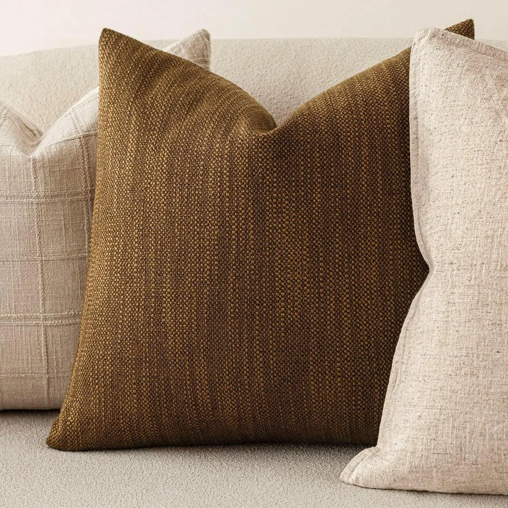 Brown chenille throw pillow cover styled on a sofa with light accent pillows