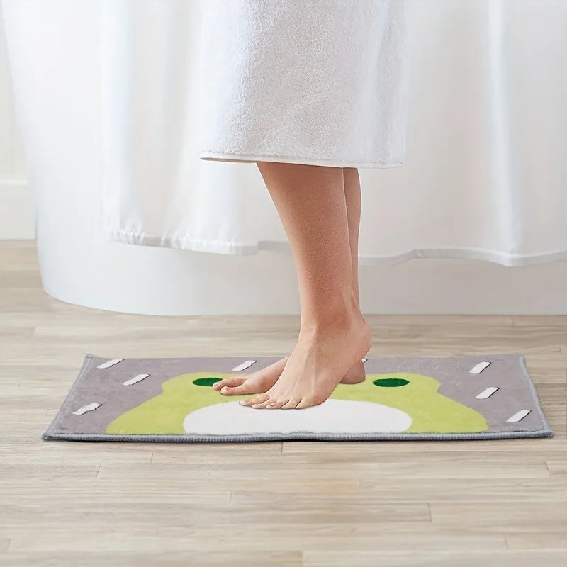 Person standing on cute frog bath mat in a bright room