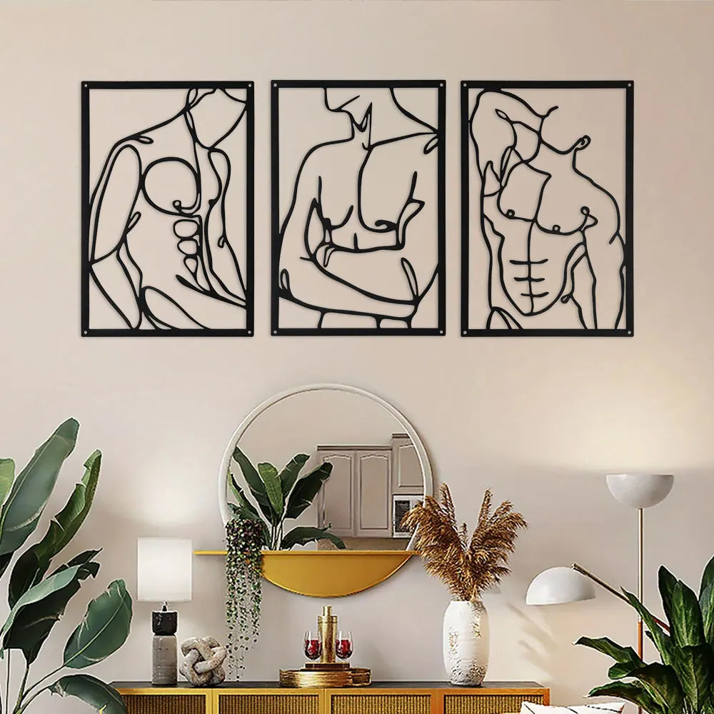 Three modern metal wall art sculptures with minimalist abstract figures above a contemporary sideboard and mirror
