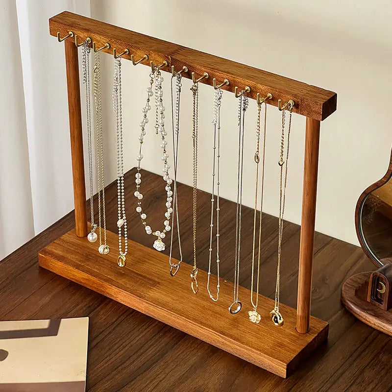 Solid wood necklace display stand with necklaces and chains on a dresser