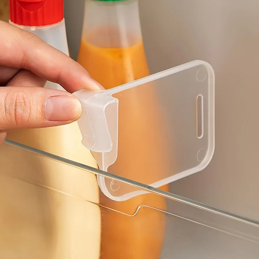 Hand attaching a clear fridge divider onto a refrigerator shelf