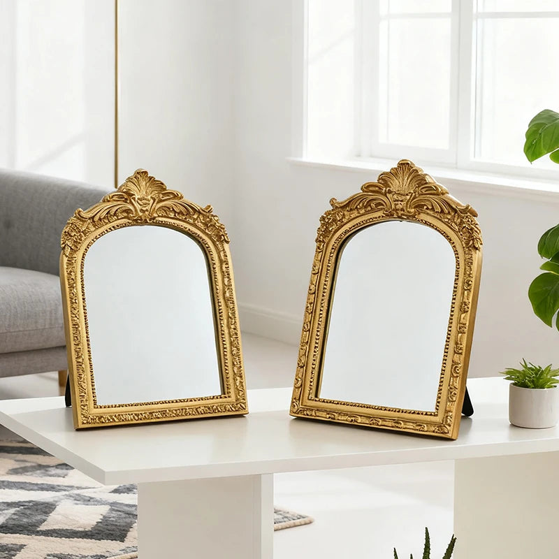 Gold frame vanity mirrors on a modern white table in a living space