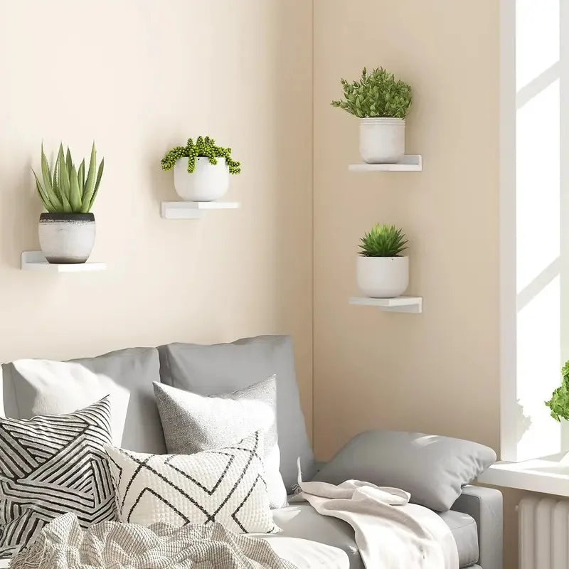 White mini floating wall shelves styled in a living room with small plants.