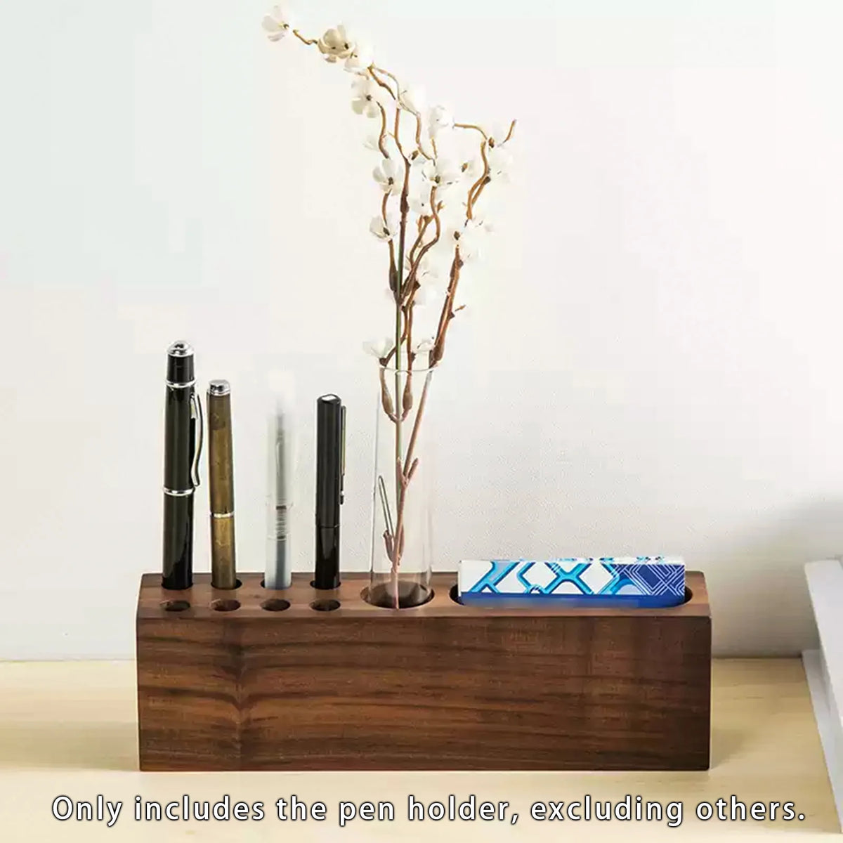 wood pen organizer holding pens, cards, and decorative flowers on a desk