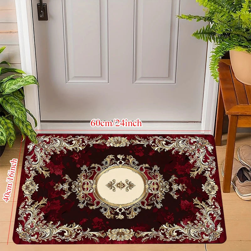 small rectangular burgundy and gold entryway doormat with ornate pattern placed by a white door and green plants, size 40x60cm