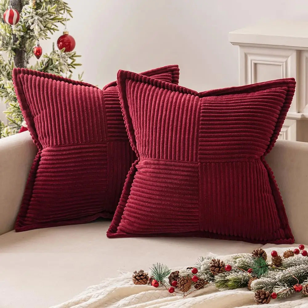 Pair of deep red corduroy striped throw pillow covers on a light sofa with holiday accents nearby