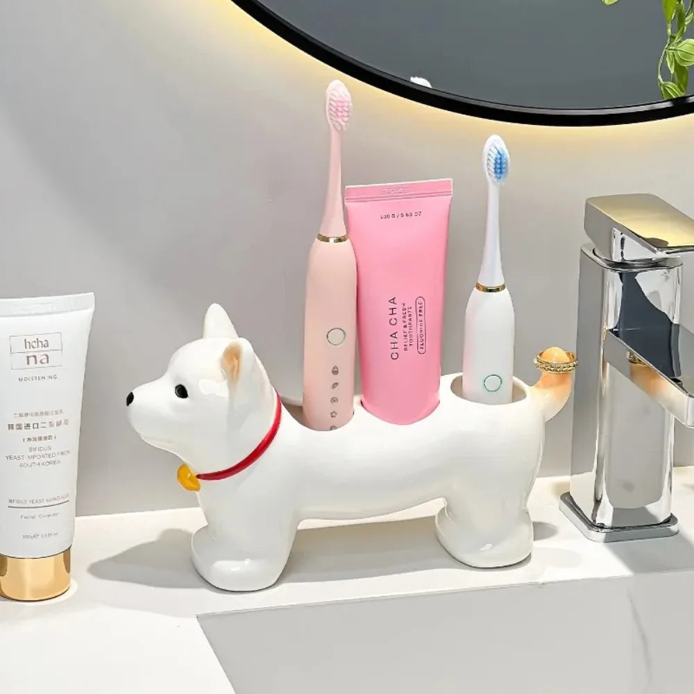 Dog-shaped toothbrush stand in white ceramic, displayed on a bathroom vanity with brushes and toothpaste inside