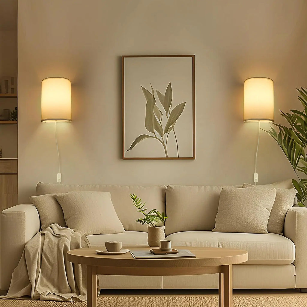 Living room scene with two beige wall sconce lamps above a sofa, offering balanced lighting