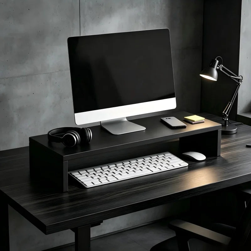 Black wooden monitor riser stand on a modern desk setup in a workspace.