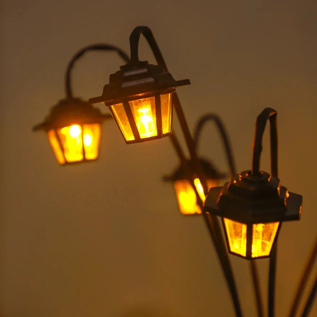 Closeup of small street lamp style solar lanterns glowing in the dark