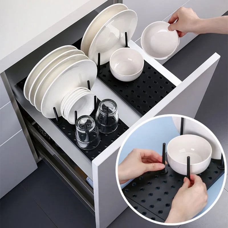 Hand placing bowl onto adjustable drawer pegboard dish organizer holding plates and glasses
