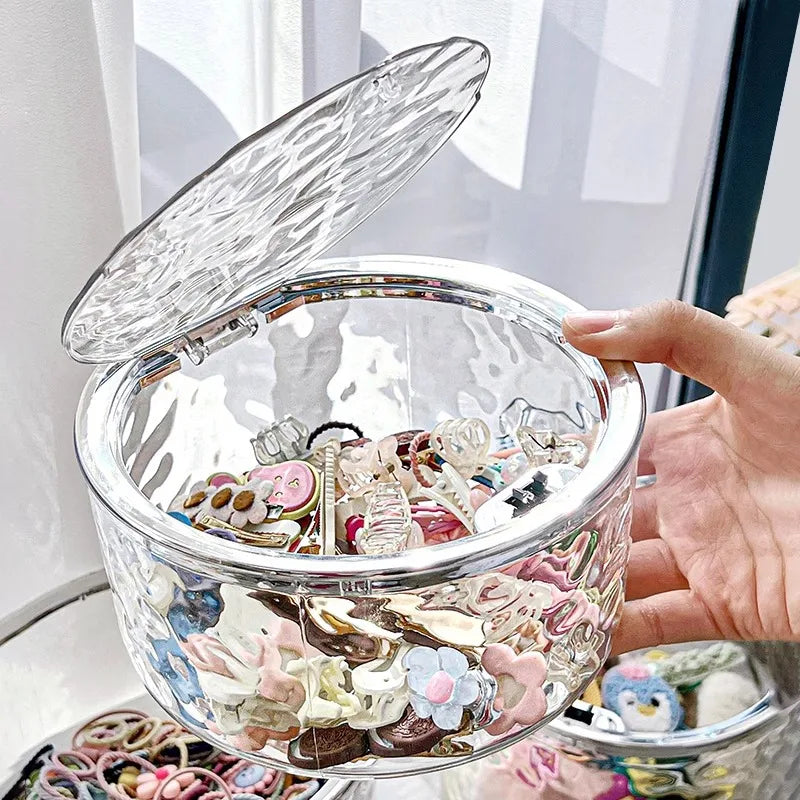 Clear textured acrylic storage box with pop-up lid holding assorted hair accessories