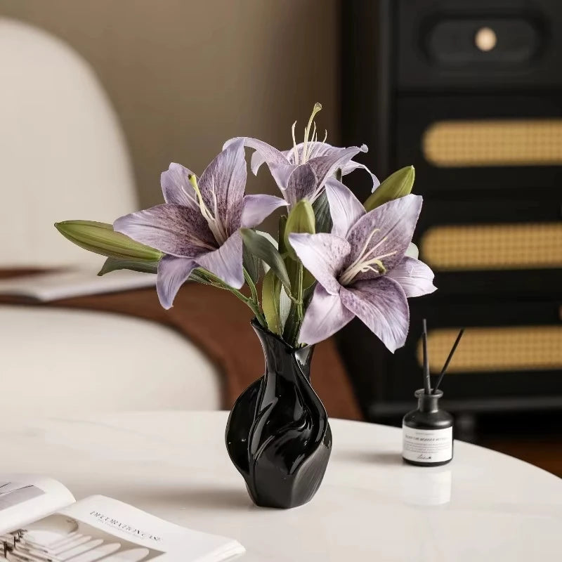 black ceramic vase with purple flowers on a living room table