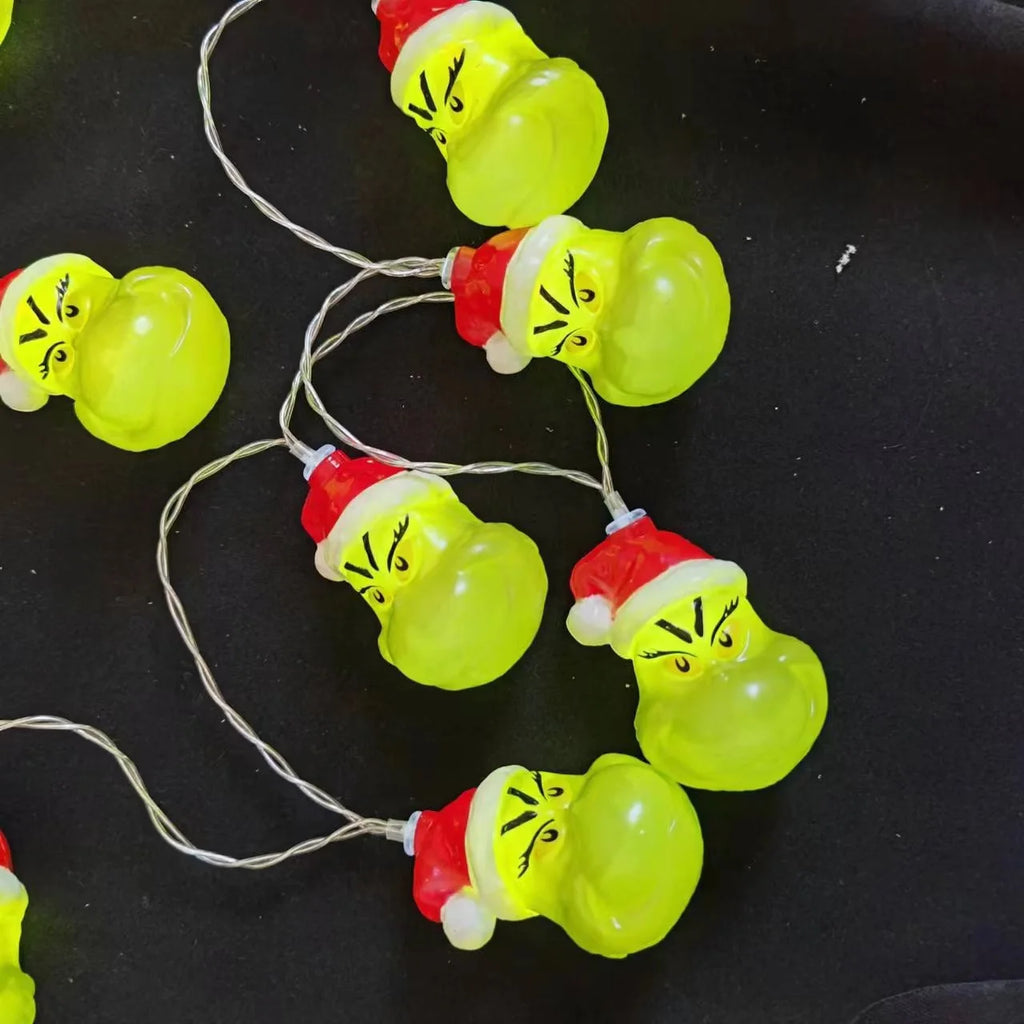 Close-up of Grinch character Christmas string lights laid out on a surface